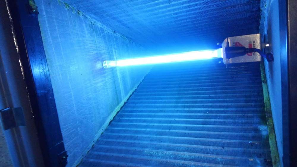 A blue light is shining down a set of stairs.