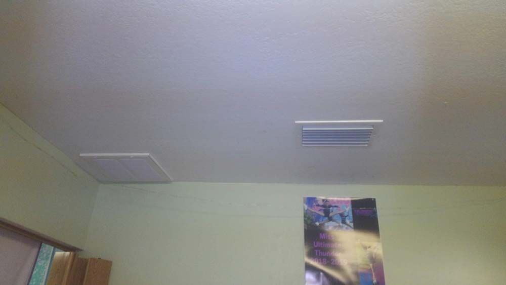 A bedroom with a ceiling fan and a picture on the wall.