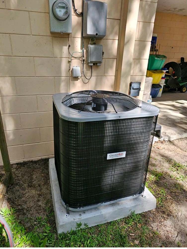 A black air conditioner is sitting on the side of a building.