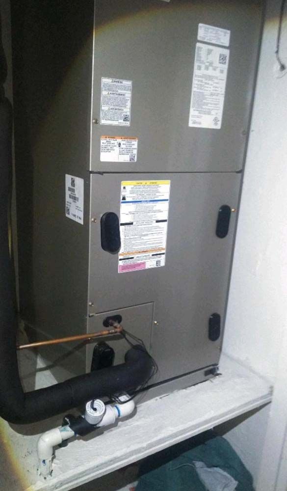 An air conditioner is sitting on top of a shelf in a room.