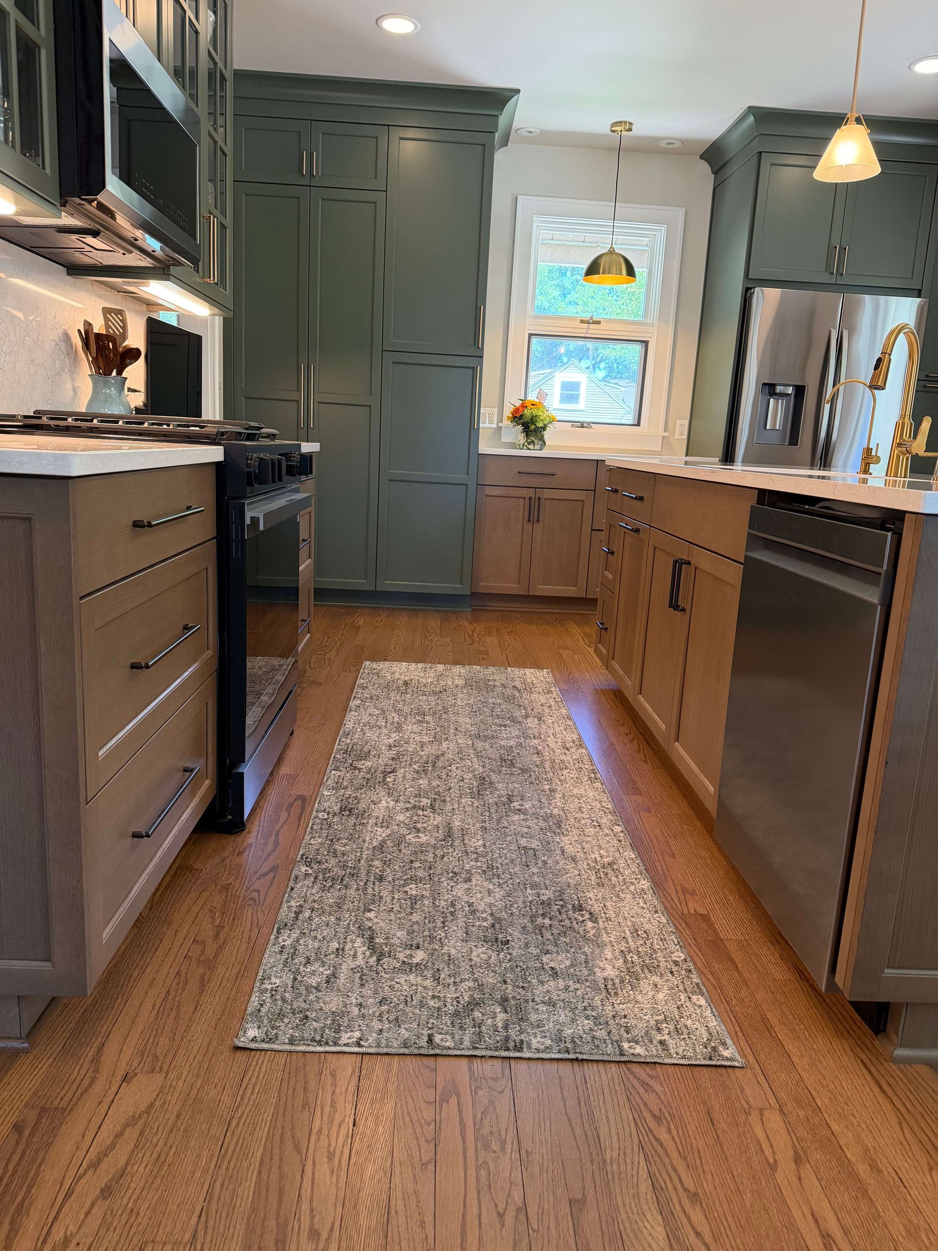 Modern kitchen remodeling with large island, four stools, black pendant lights, and white cabinets in Glenview, IL