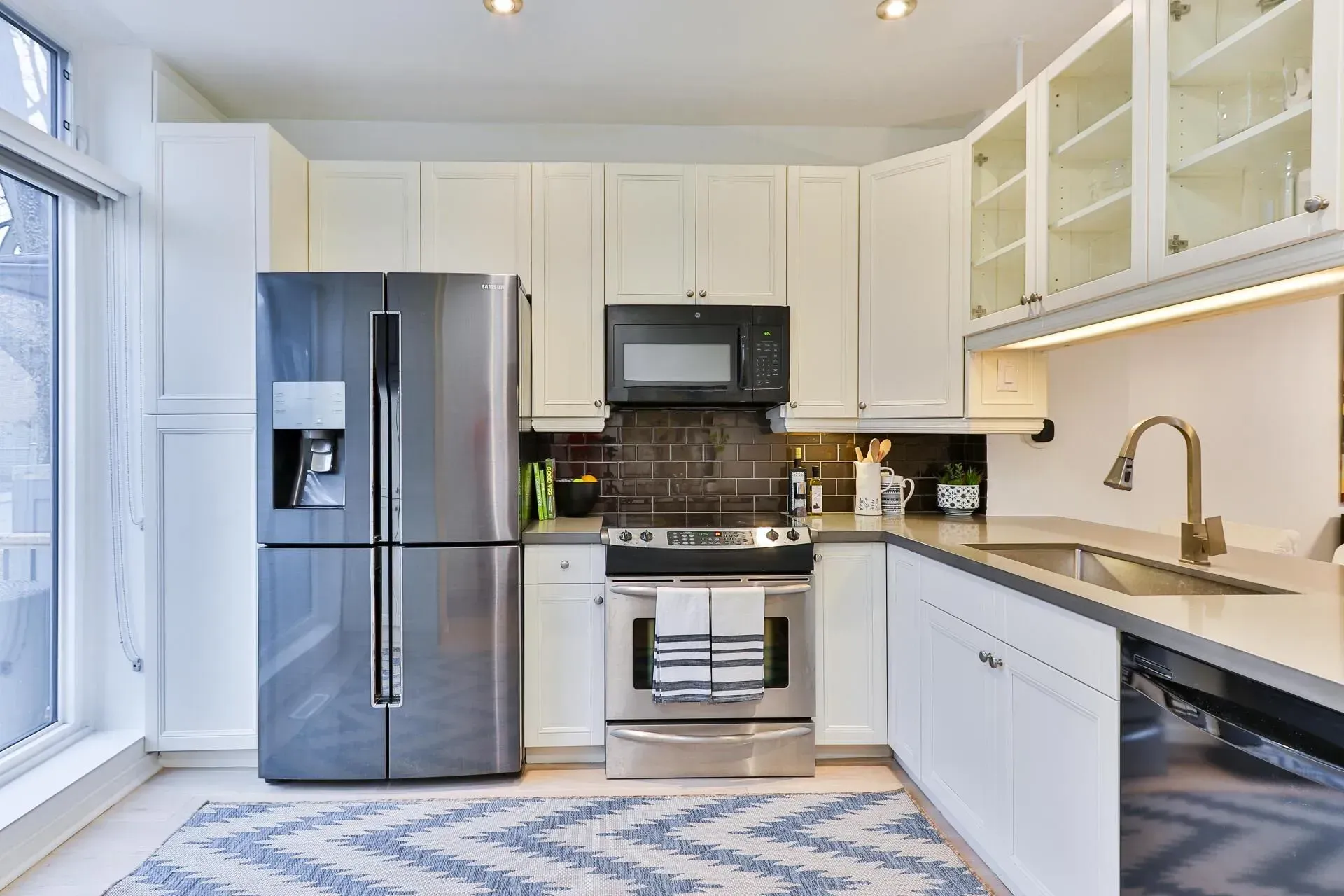 A kitchen with stainless steel appliances and white cabinets.