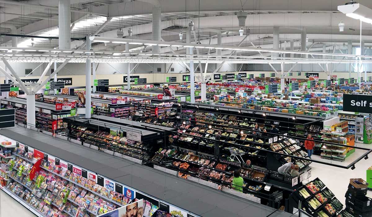 Inside a supermarket looking at the roof and different food aisles