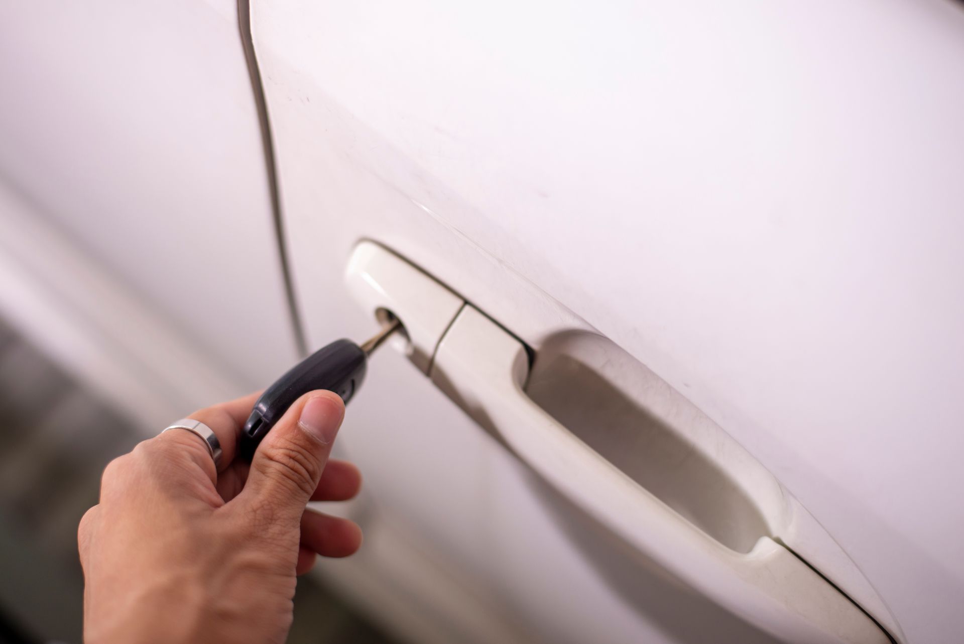A man is using the key to unlock the car's door.