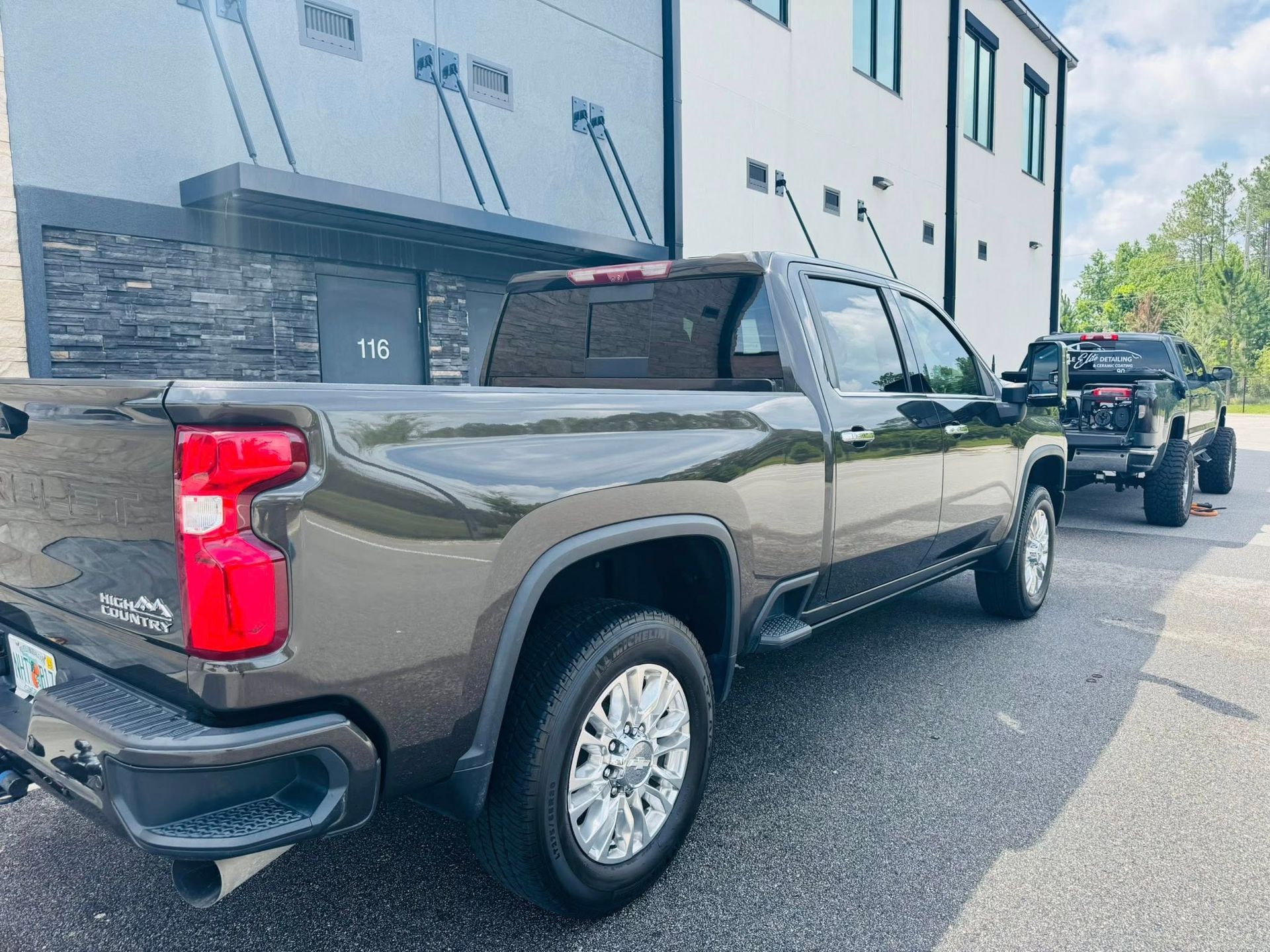 A black truck is parked in front of a building.