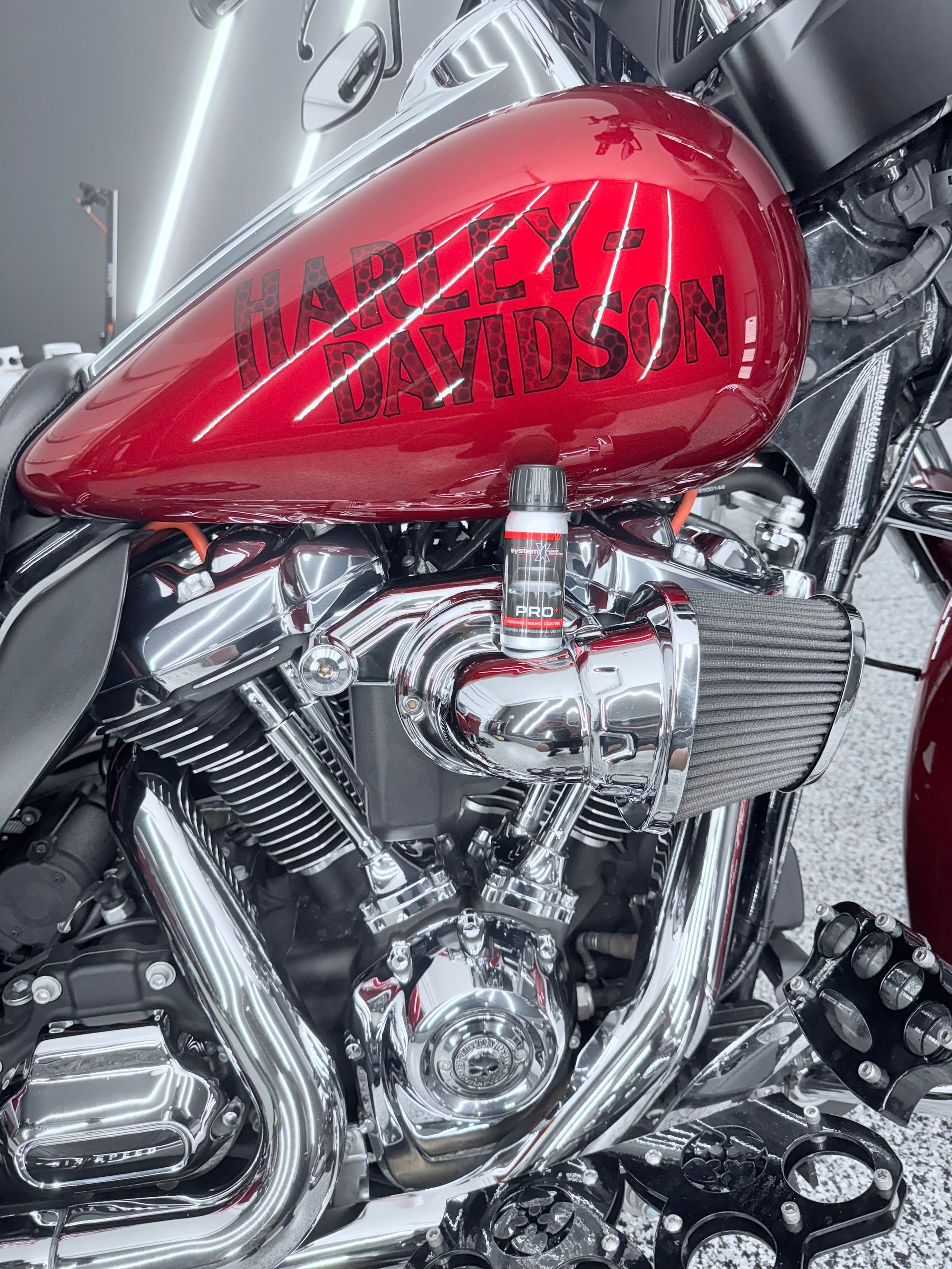 A gray sports car is parked in a driveway in front of a garage.
