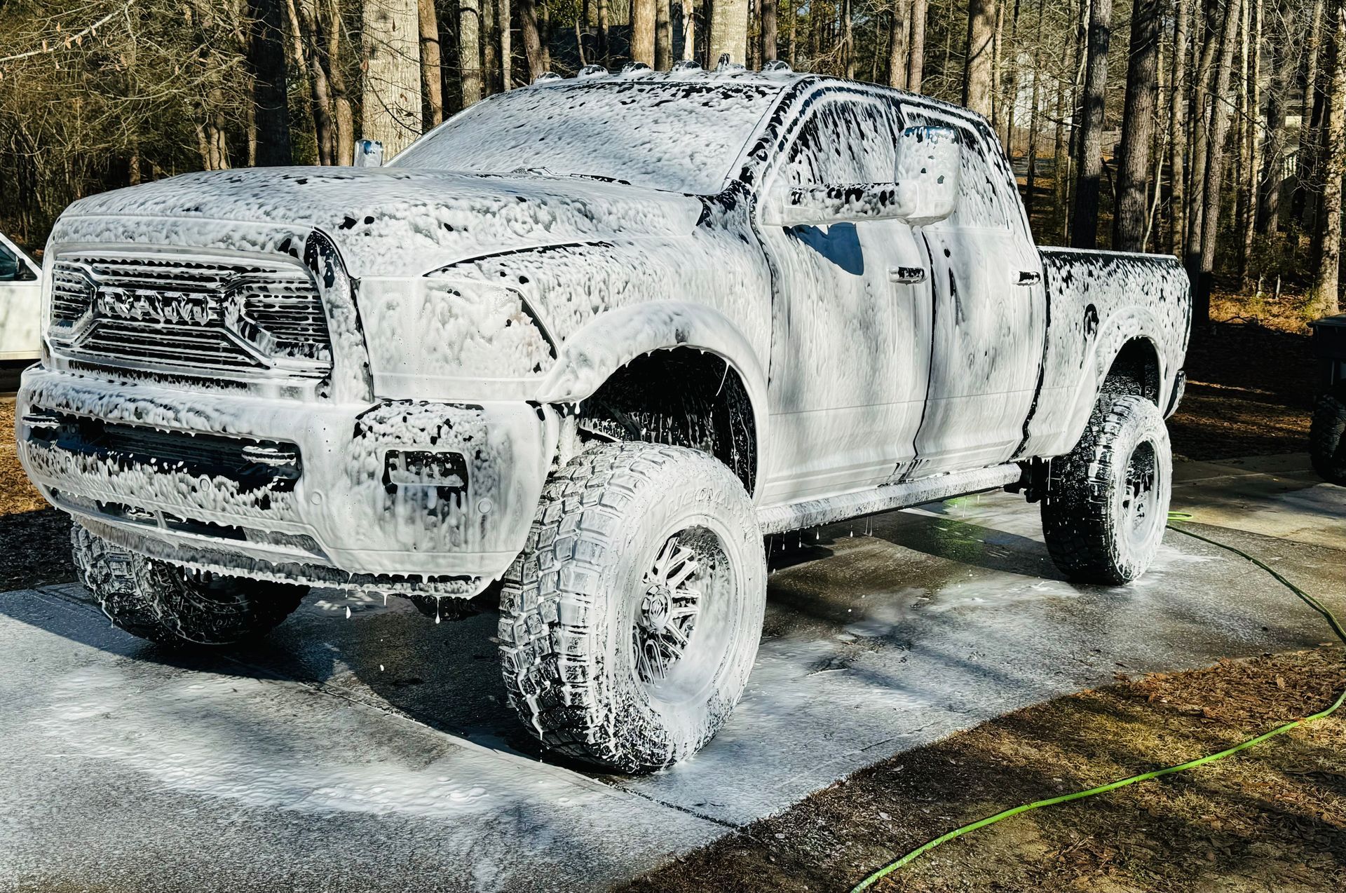 A black sports car with red brake calipers is parked in a parking lot.