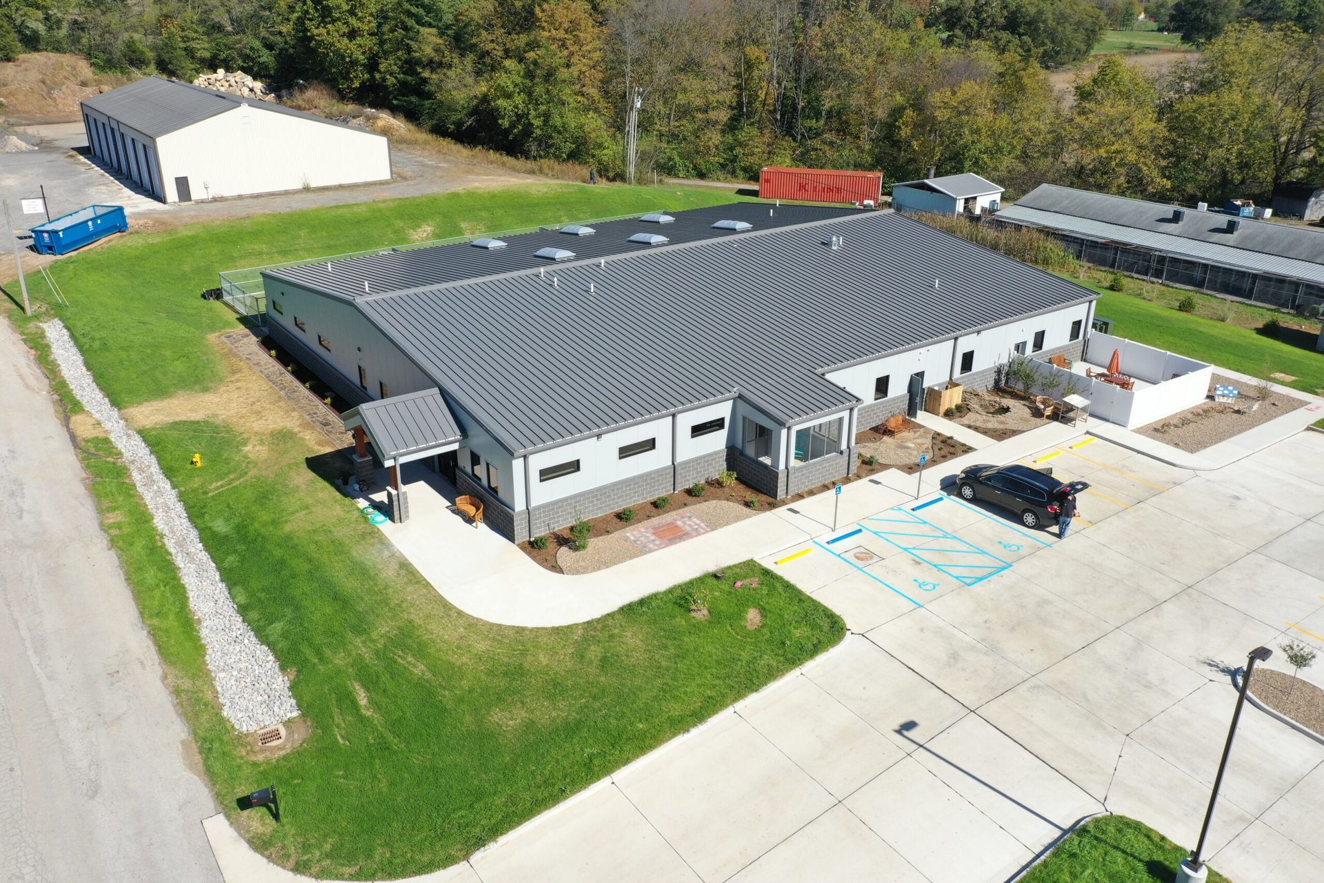 An aerial view of a large building with a parking lot in front of it.