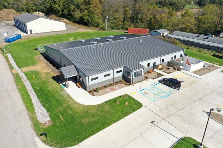 An aerial view of a large building with a parking lot in front of it.