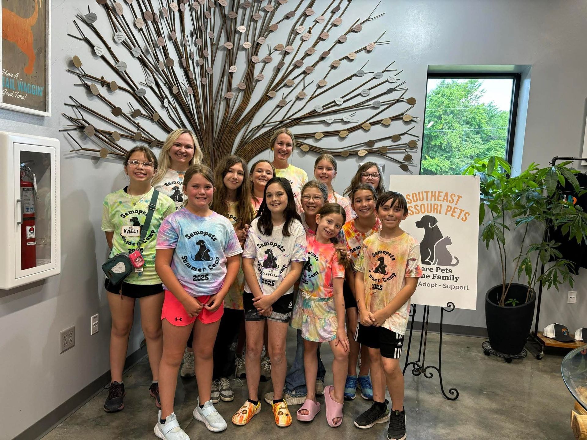 A group of young girls are posing for a picture in a room.