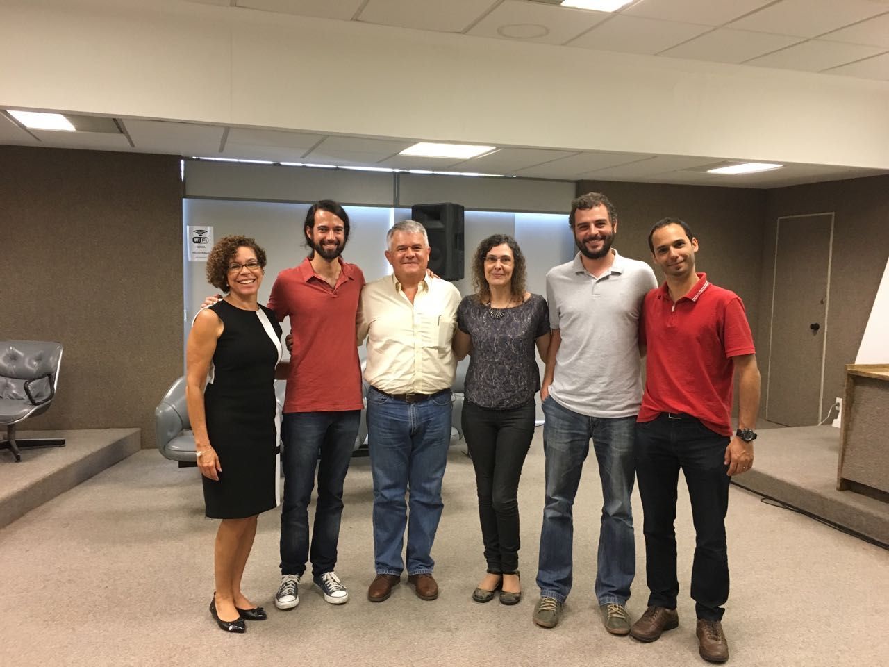 Um grupo de pessoas posa para uma foto em uma sala.