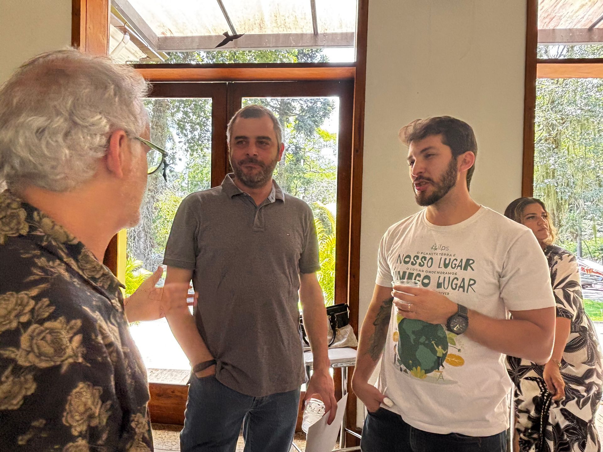 Um grupo de pessoas posa para uma foto em frente a uma tela de projetor.