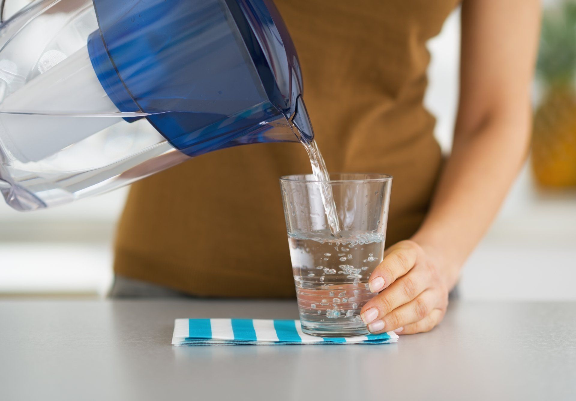 housewife pouring water into glass