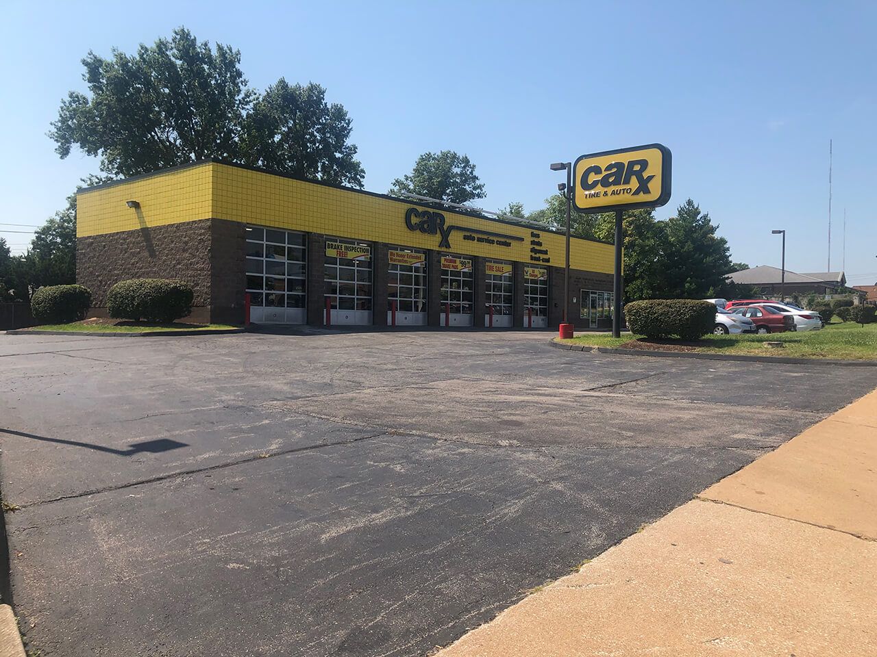 Car repair shop with yellow and brown exterior, sunny day.