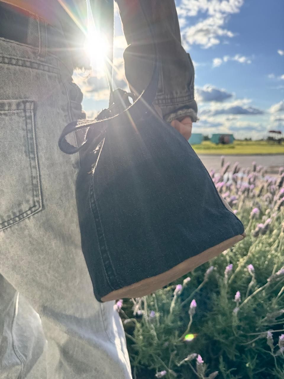 Pasta y hierbas en recipientes de plástico transparente y herméticos con tapas negras. Sobre un fondo de madera blanca.