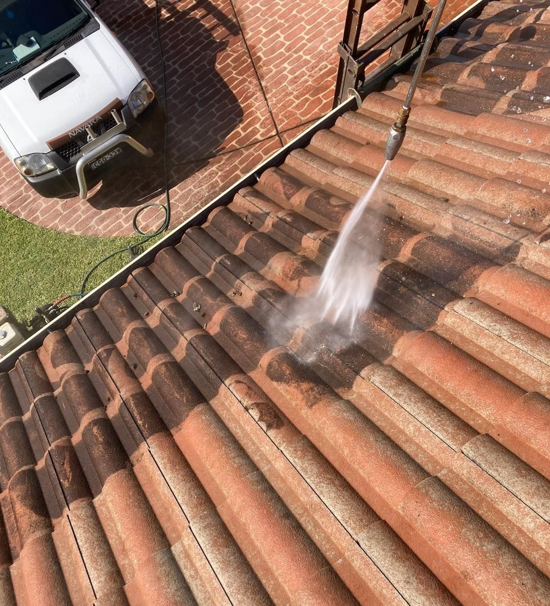 A roof is being cleaned with a high pressure washer. — Wayne Treasure Roofing & Restoration In Forster, NSW