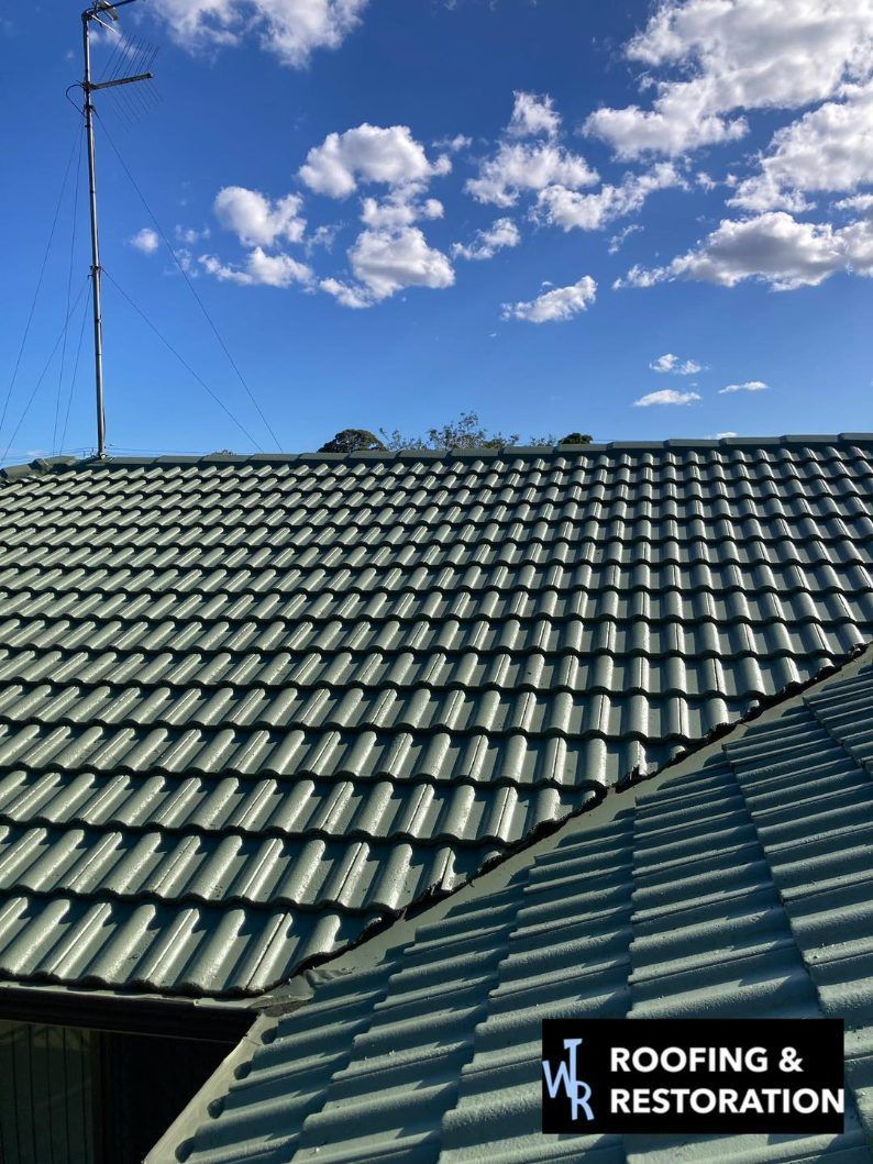 A Roof With a Blue Sky and Clouds in the Background — Wayne Treasure Roofing & Restoration In Taree, NSW