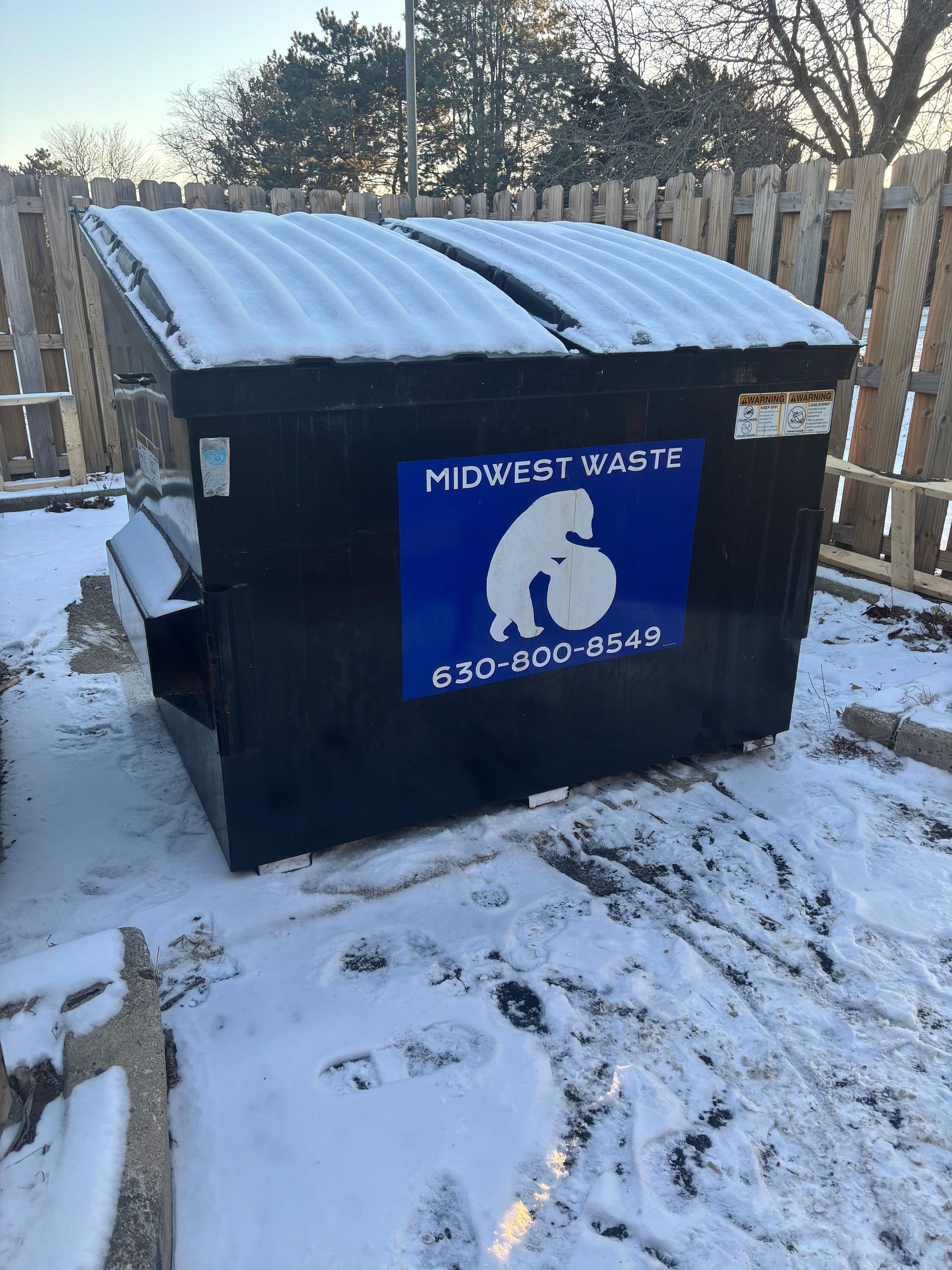 A black dumpster with a blue 