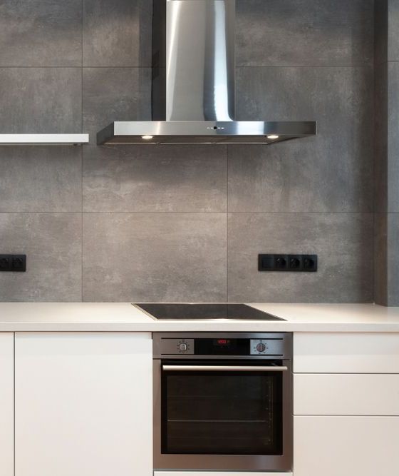 A kitchen with a stove top oven and a range hood above it  β AJ Services in Alice Springs, NT