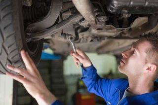 Auto mechanic working under car — Volkswagen Maintenance & Repair in Queenstown, MD