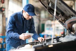 Mechanic using a tablet in his garage — Volkswagen Repair in Queenstown, MD