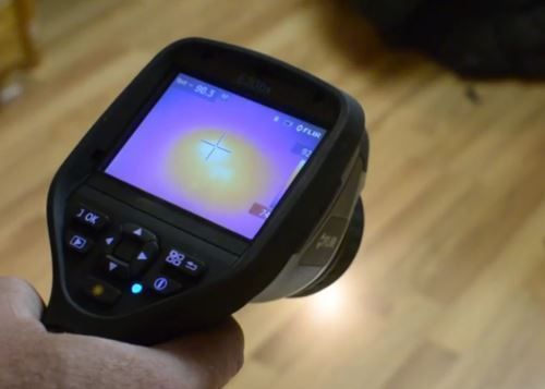 A person is holding a thermal camera in their hand