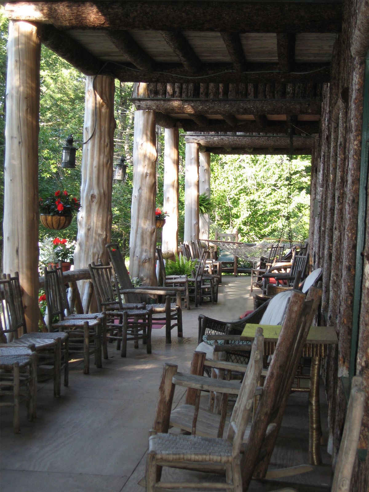 a row of rocking chairs are lined up on a porch