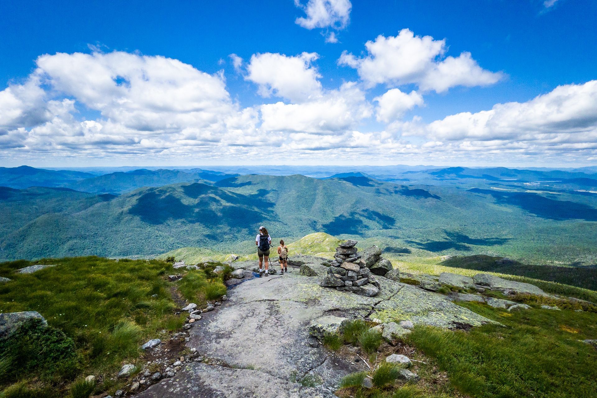 A couple of people are standing on top of a mountain.