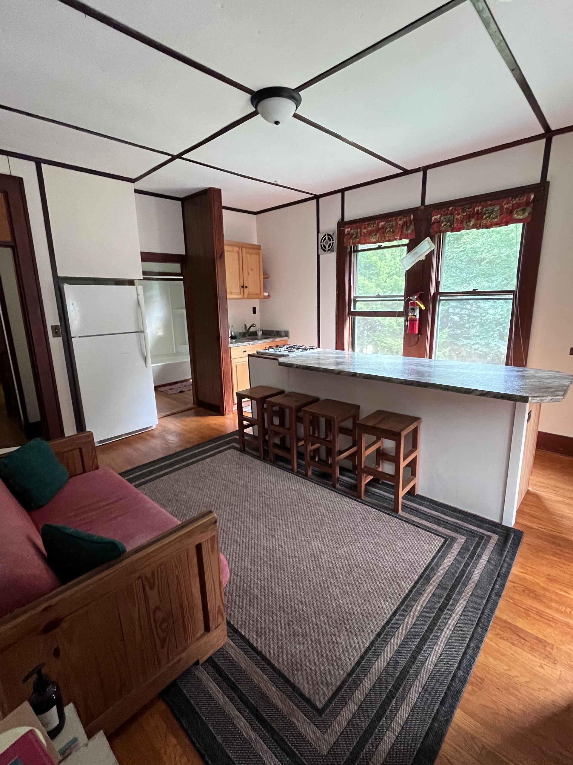 a living room with a bar and stools in it