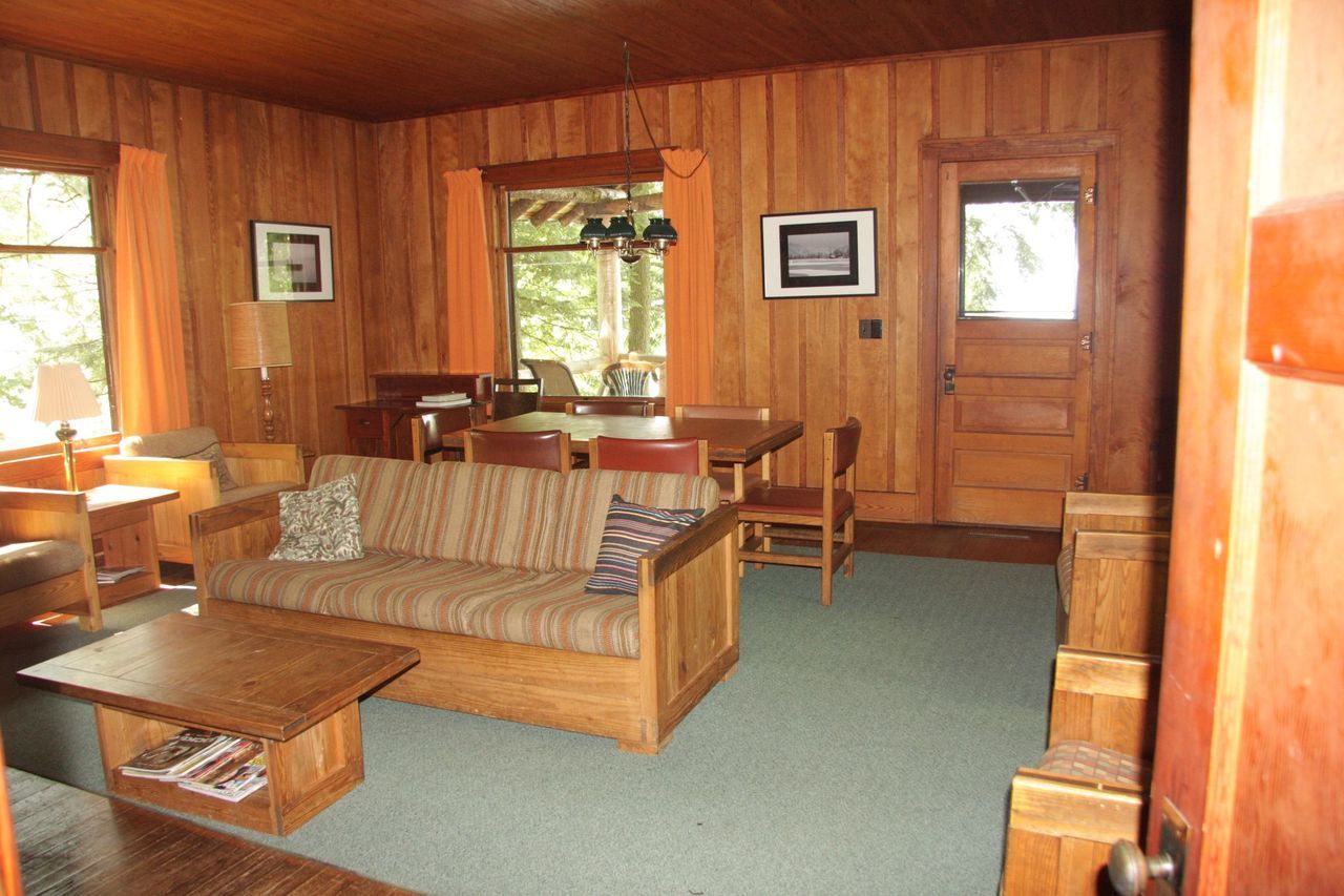 a living room with wood paneling and a couch