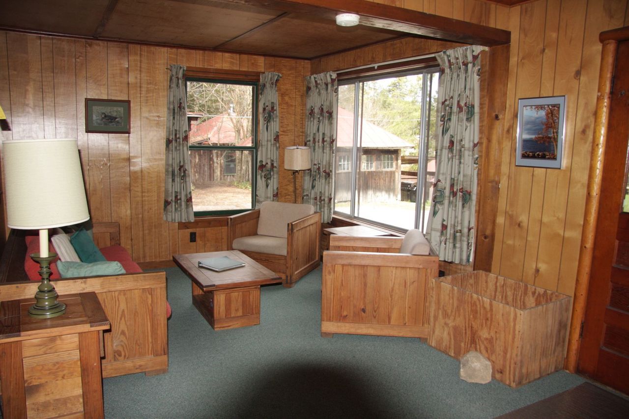 a living room with wood paneling and a large window