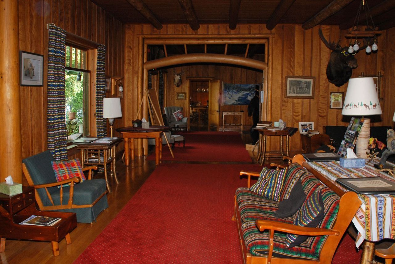 a living room with wood paneling and a couch and chairs