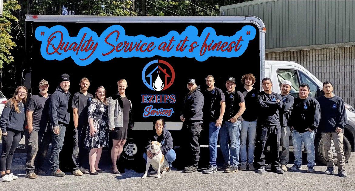 A group of people standing in front of a truck that says quality service at it 's finest.