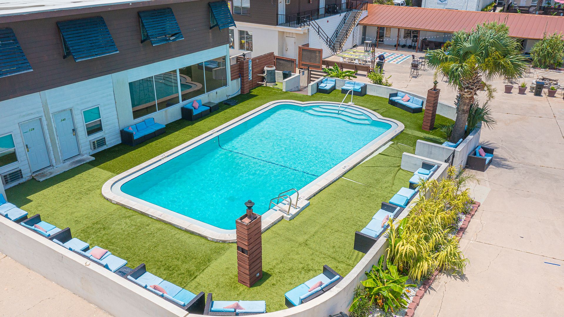 An aerial view of a large swimming pool in front of a building.