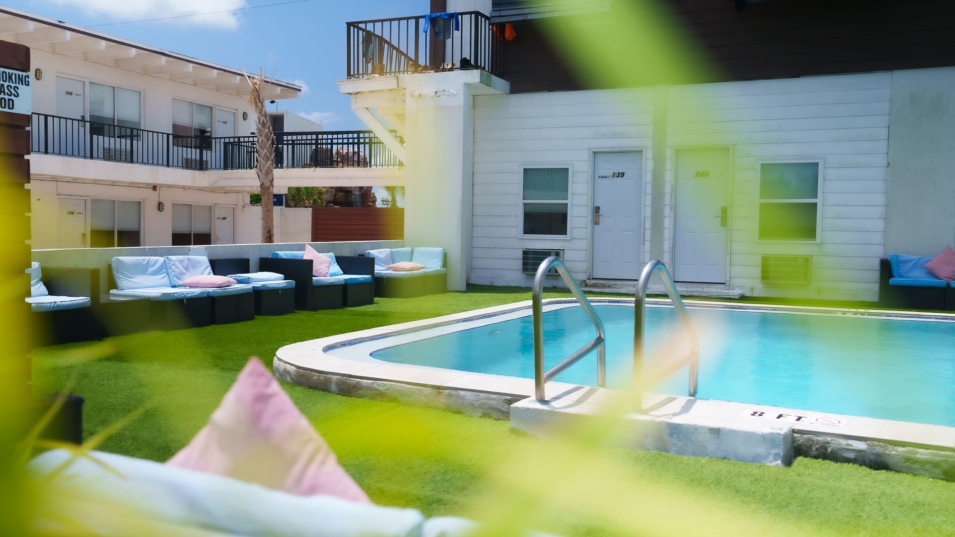 A swimming pool with stairs leading to it in front of a building