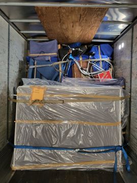 A moving truck filled with lots of boxes and furniture.