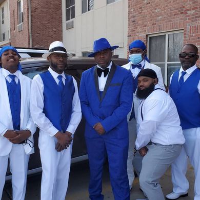 A group of men in blue suits and white shirts are posing for a picture