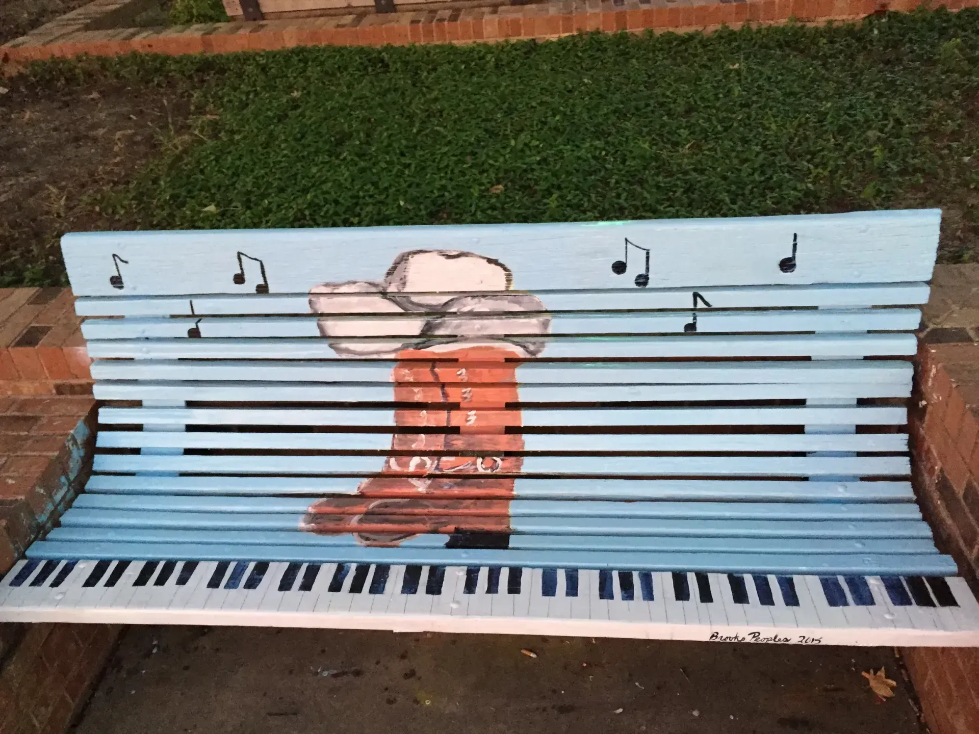 Silhouette of a woman carrying a basket with branches on her head.