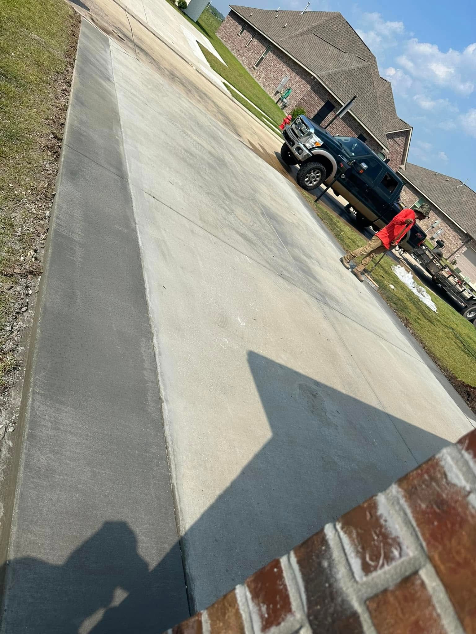 Concrete driveway on a steep incline with a black truck parked, residential setting.