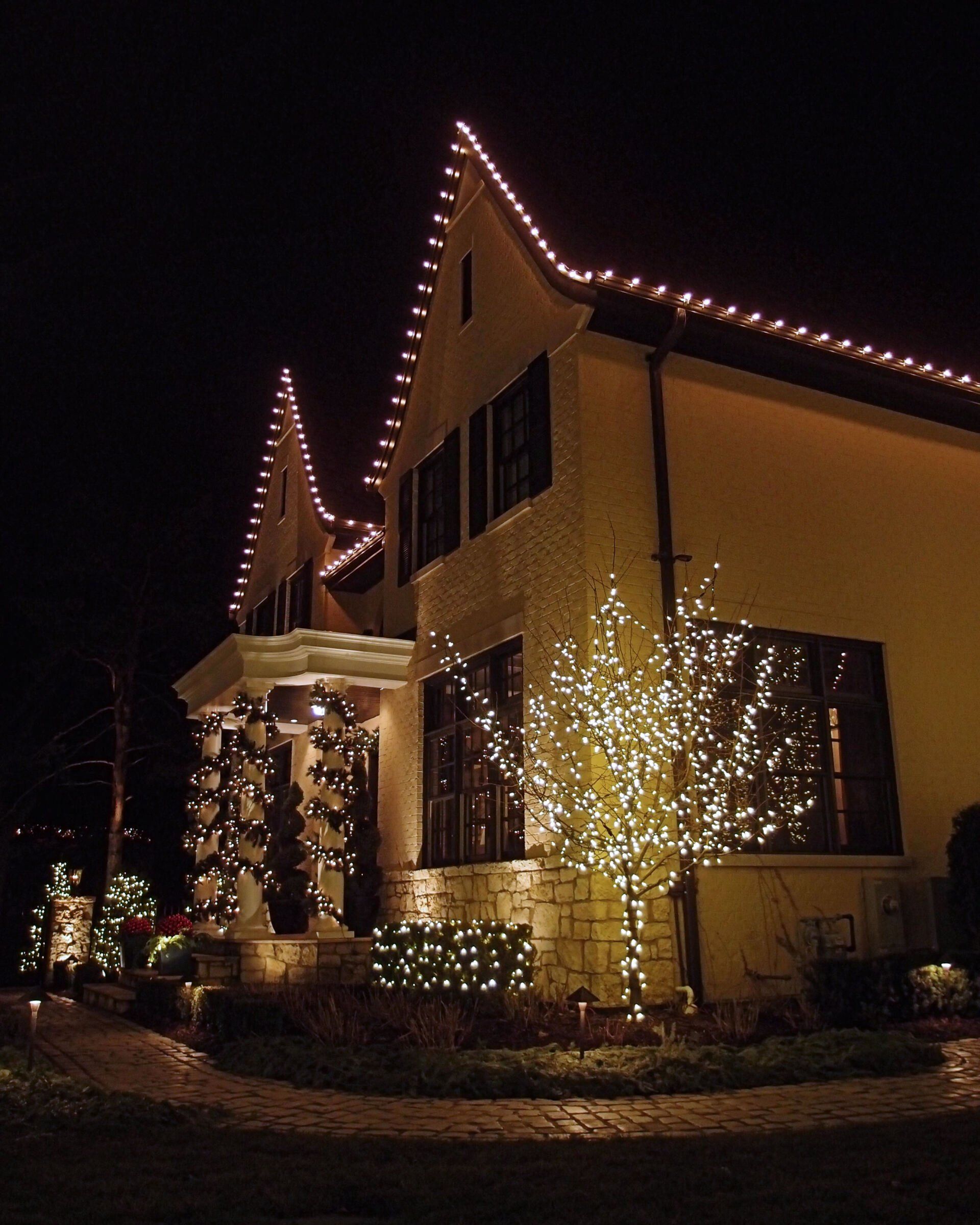 Custom Christmas lights wrapping a Minnetrista, MN home surrounded by woods