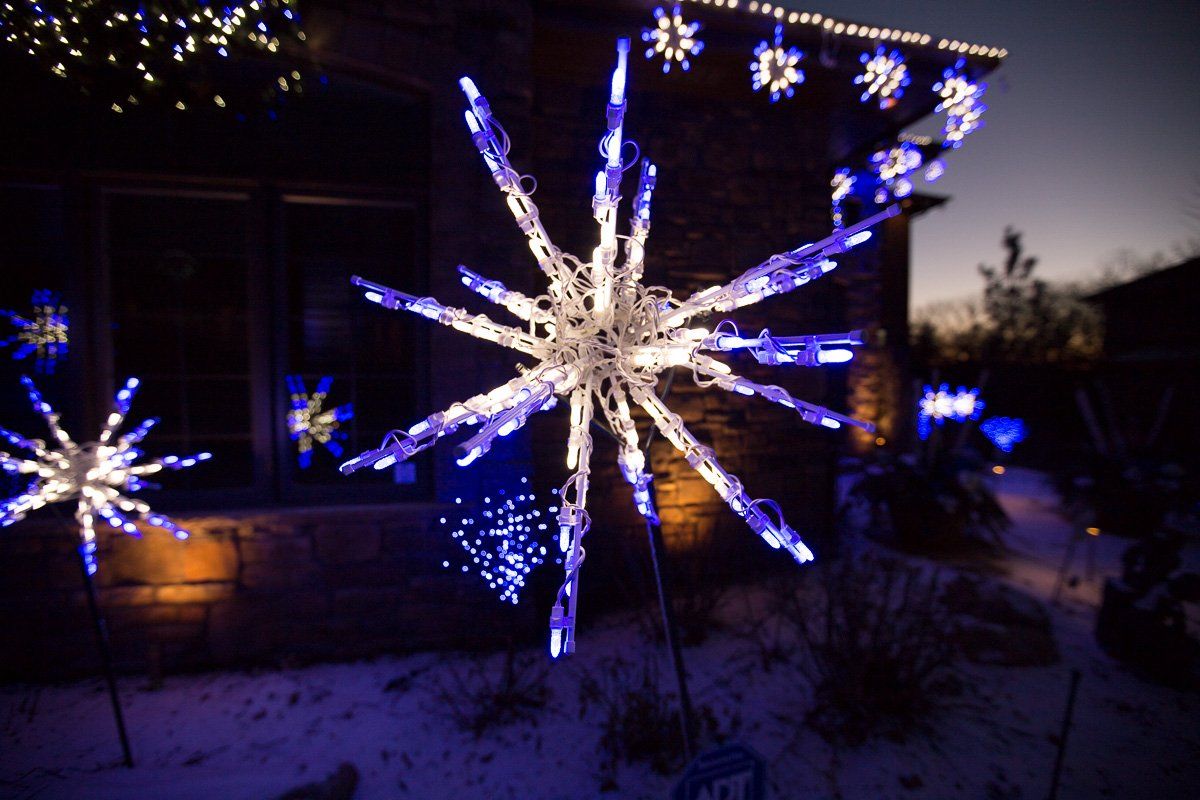 A house is decorated with blue and white christmas lights