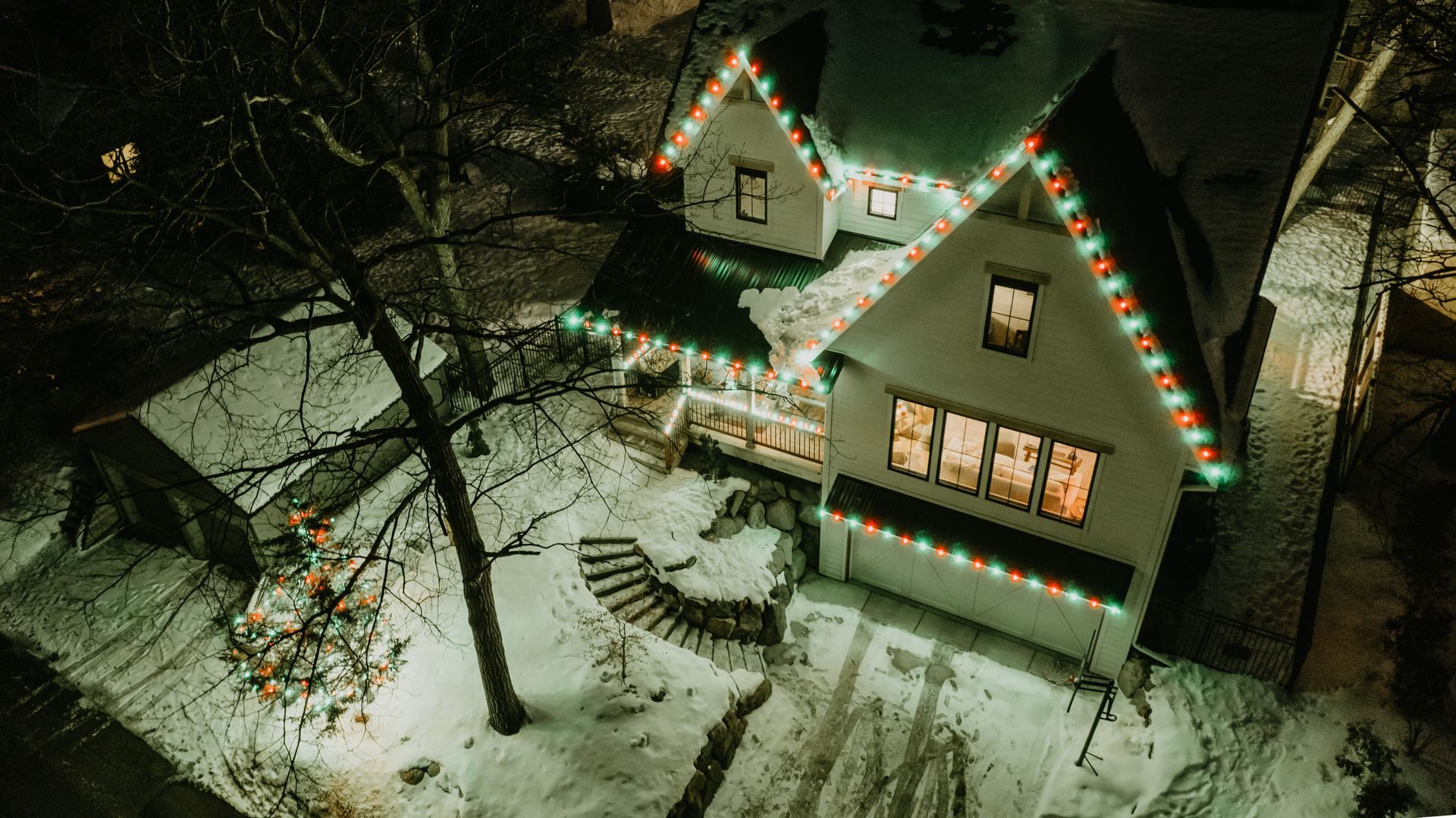 Charming Christmas lights wrapped around a vintage Excelsior, MN cottage installed by Jingle Bulbs
