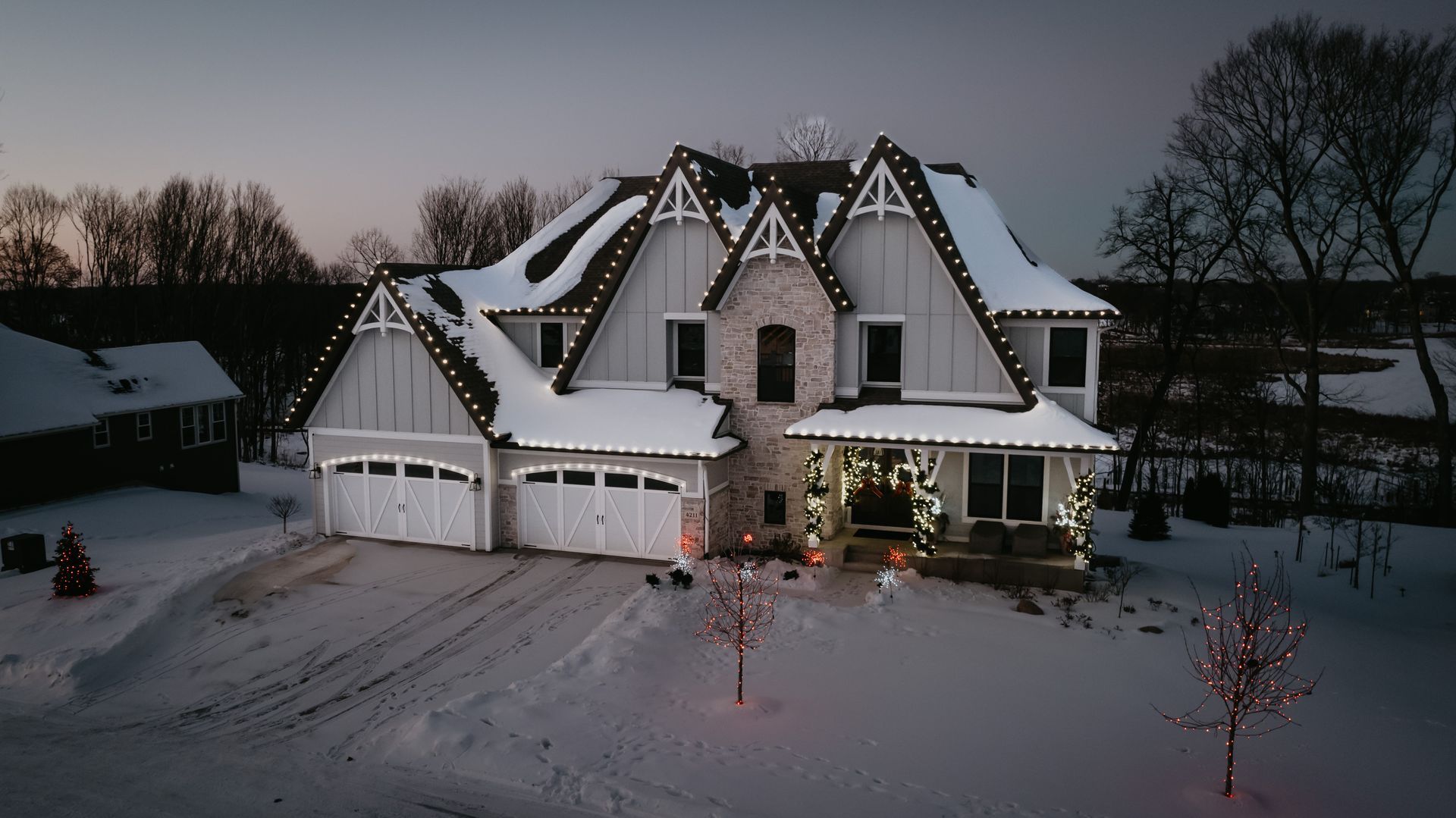 Snow-covered roofline outlined with holiday lights in Maple Grove, MN’s Arbor Lakes neighborhood