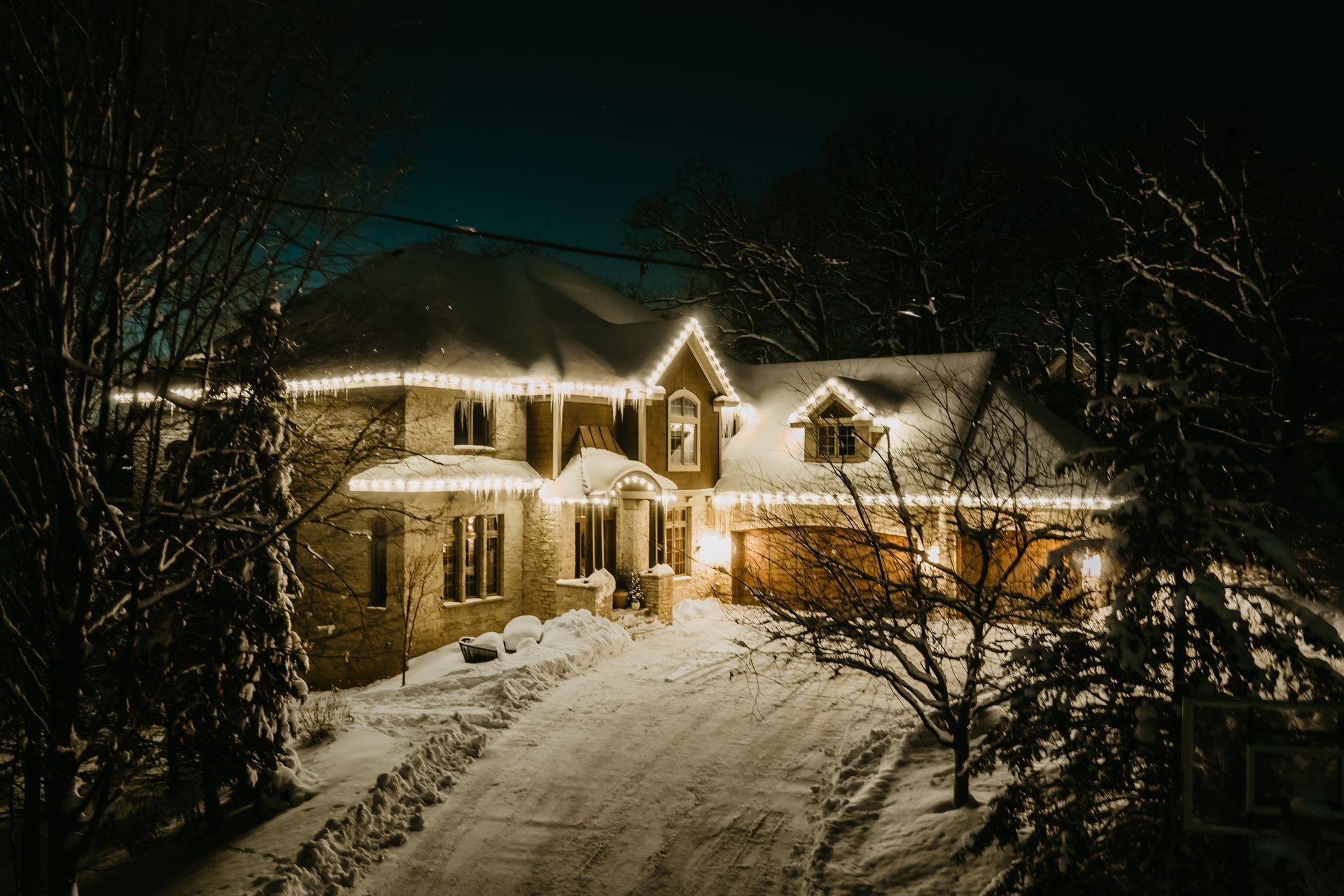 a house is lit up with christmas lights at night