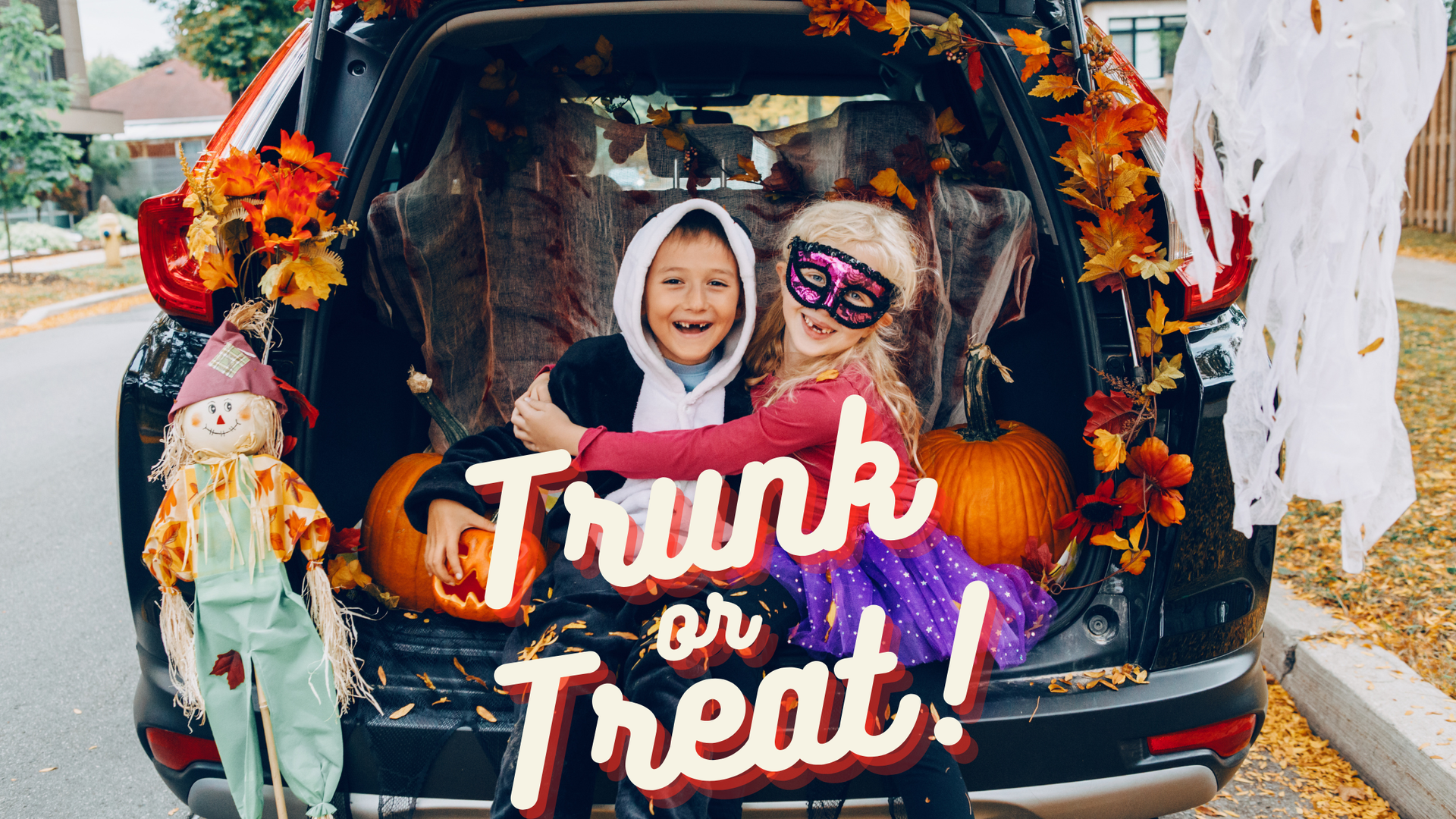 Kids sitting on a trunk with Halloween decorations 