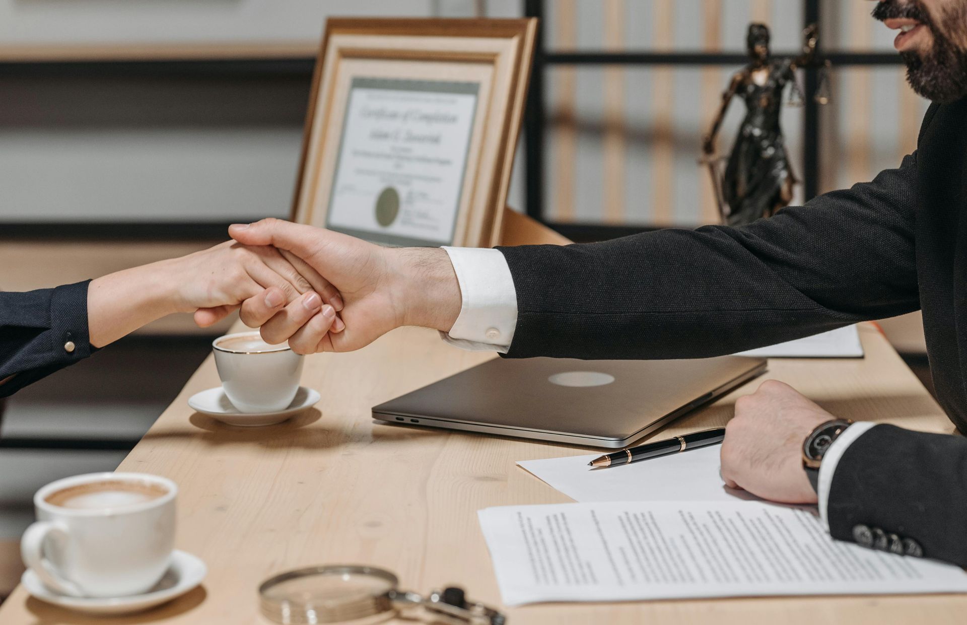 a man and a woman are shaking hands over a table.