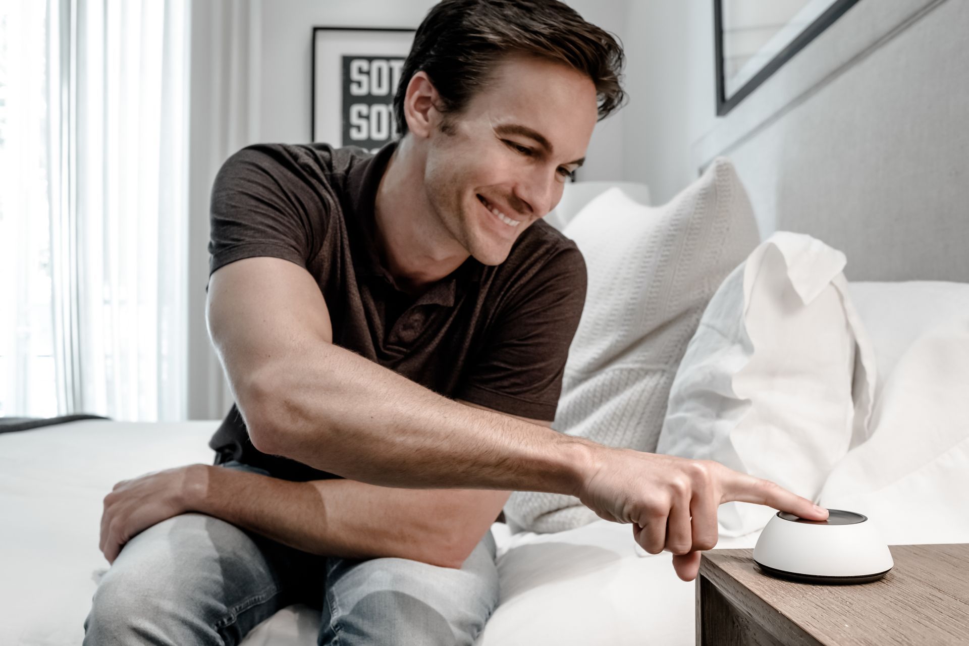 Un homme est assis sur un canapé et utilise un appareil intelligent.