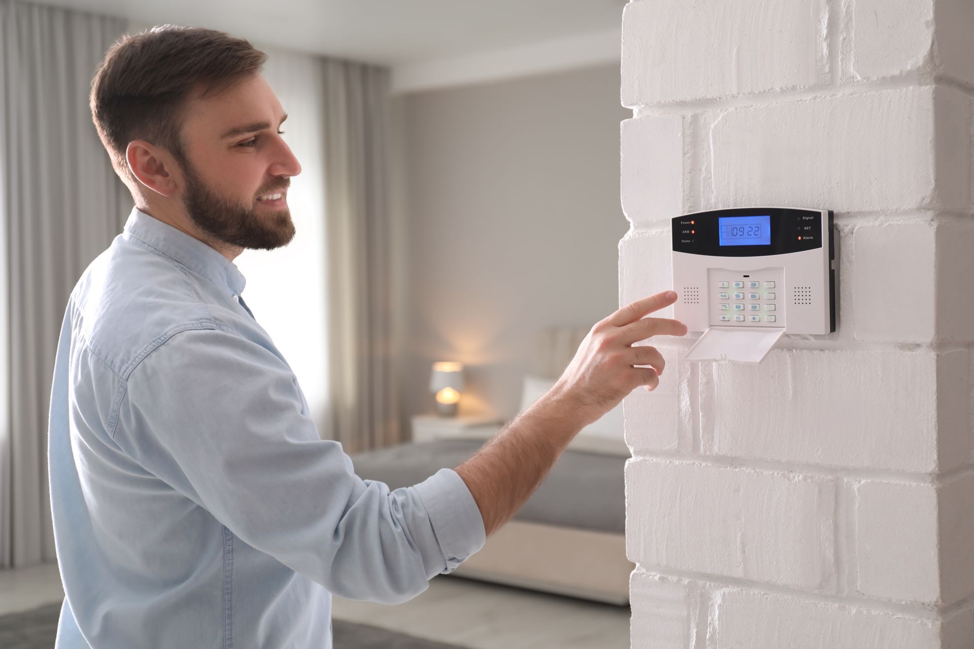 A man is pressing a button on a security system.