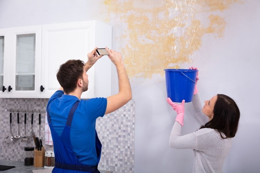 Homeowner photographing storm property damage for insurance