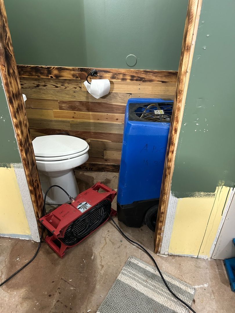 Dehumidifier and air movers set up in Hartville bathroom for professional water damage drying